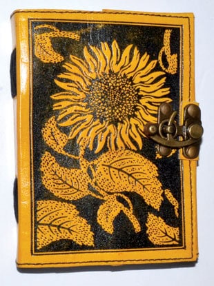 A small book with a sunflower design on the cover, featuring a metal clasp, related to Celtic spirit.