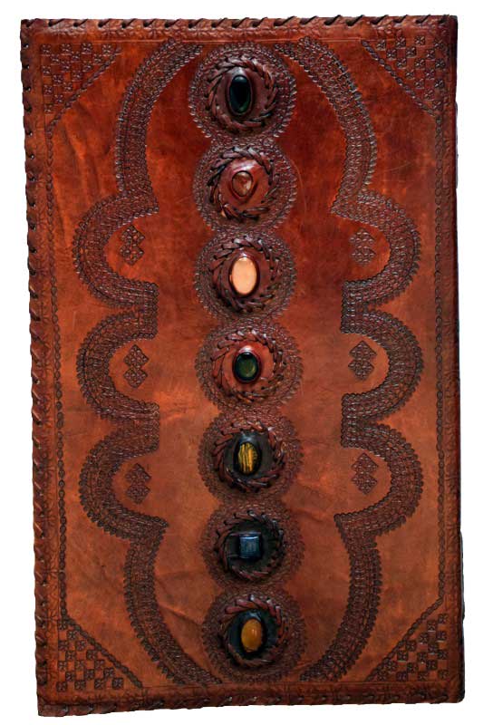 Ancient leather ogham tablet featuring carved symbols and embedded colored stones, used in Celtic sp.