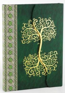 A journal with a green cover featuring a gold Celtic tree of life design and decorative border on th.