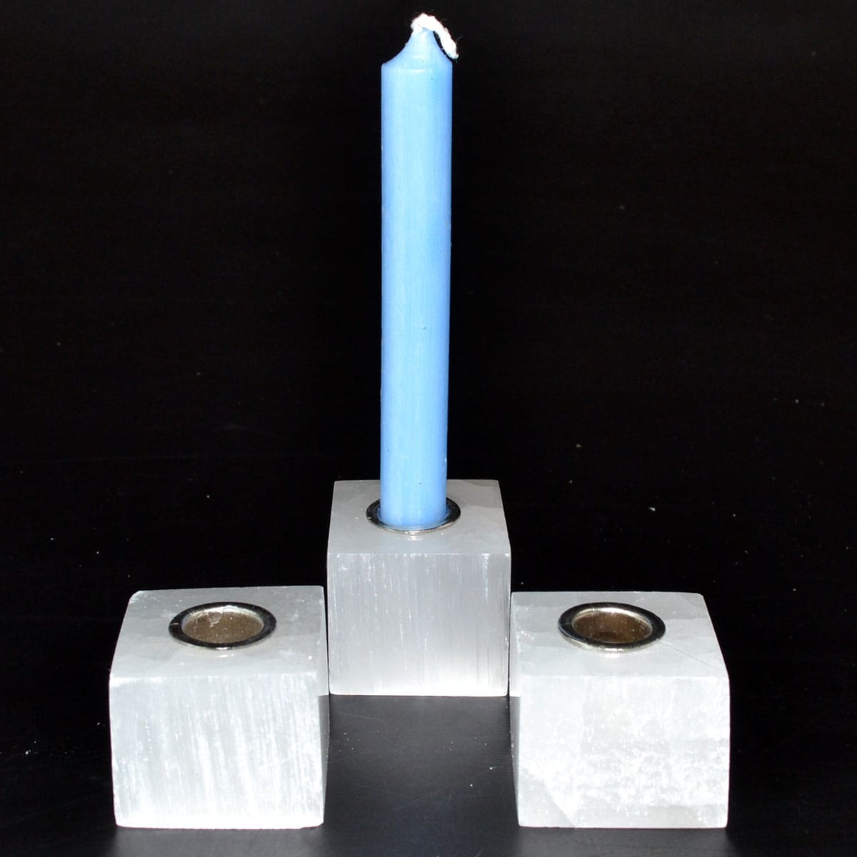 Candle holder with blue candle, simple design, on a black background.
