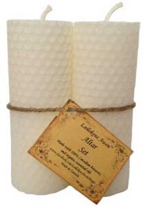 Candle with textured surface and attached tag, used in Celtic spiritual practices.