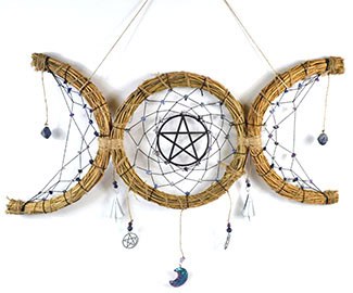 Handmade dreamcatcher with pentagram and moon charms, symbolizing Celtic spirituality and nature con.