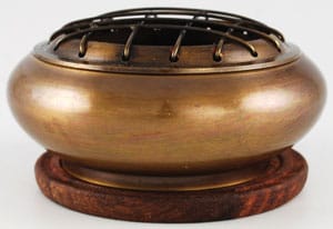 Bronze burning bowl used in Celtic spiritual practices, placed on a wooden stand.