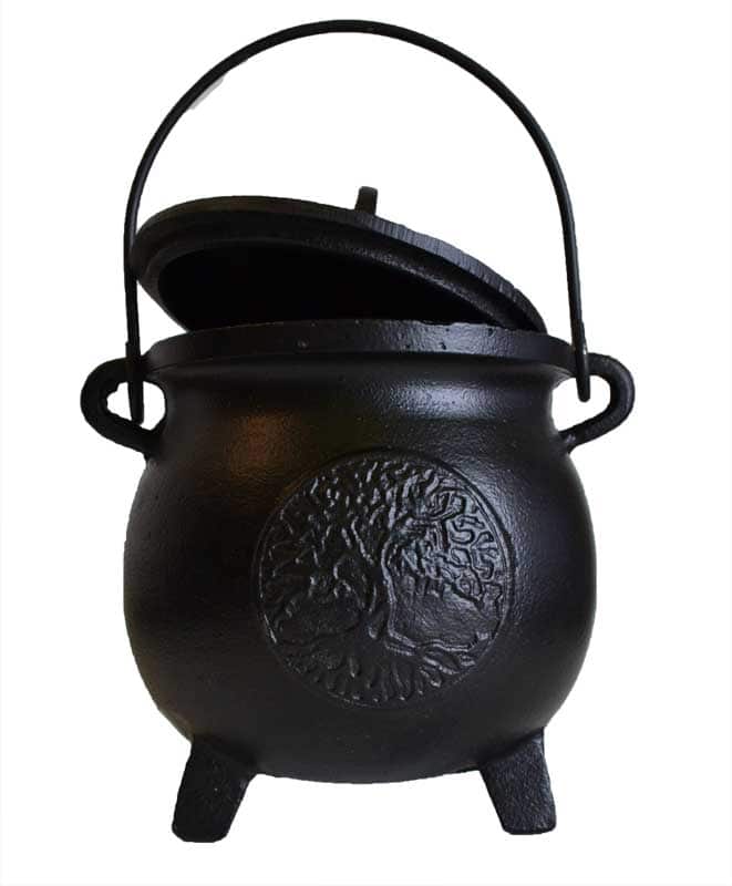 Black cast iron cauldron with tree emblem, used in Celtic spiritual practices and nature veneration.