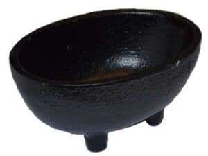 Black stone cauldron with three legs, used in Celtic spiritual practices.