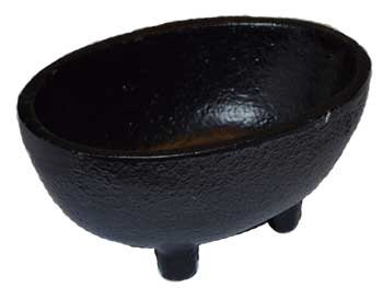 Black stone cauldron with three legs, used in Celtic spiritual practices.