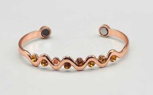 Bracelet with amber stones and wave pattern in rose gold.