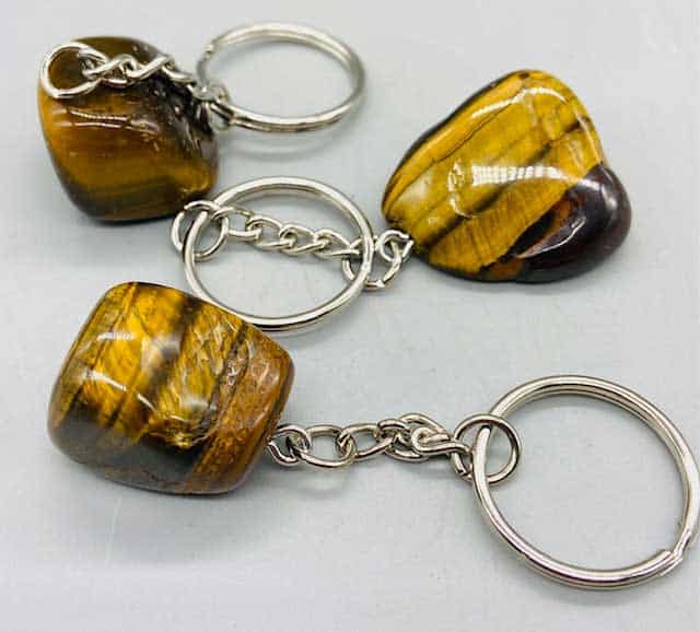 Keychains made of polished Tiger's Eye stones with metal rings and chains.