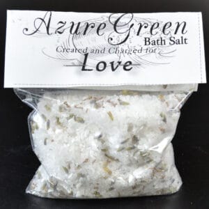 Bath salt with dried herbs and floral elements.