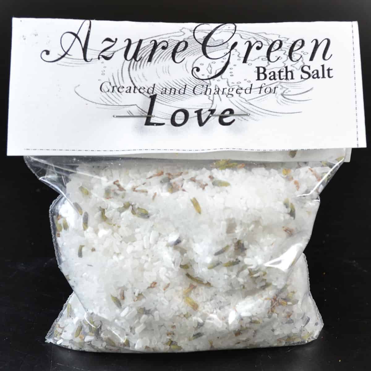Bath salt with dried herbs and floral elements.