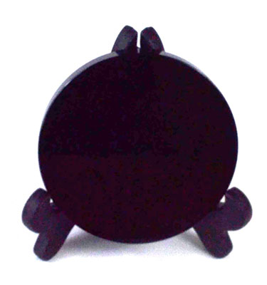 Stone circle or stand for ritual use, dark color, simple design, with small supporting legs.