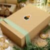 Elegant gift box wrapped with green ribbon, decorated with Celtic-inspired design and festive surroundings.