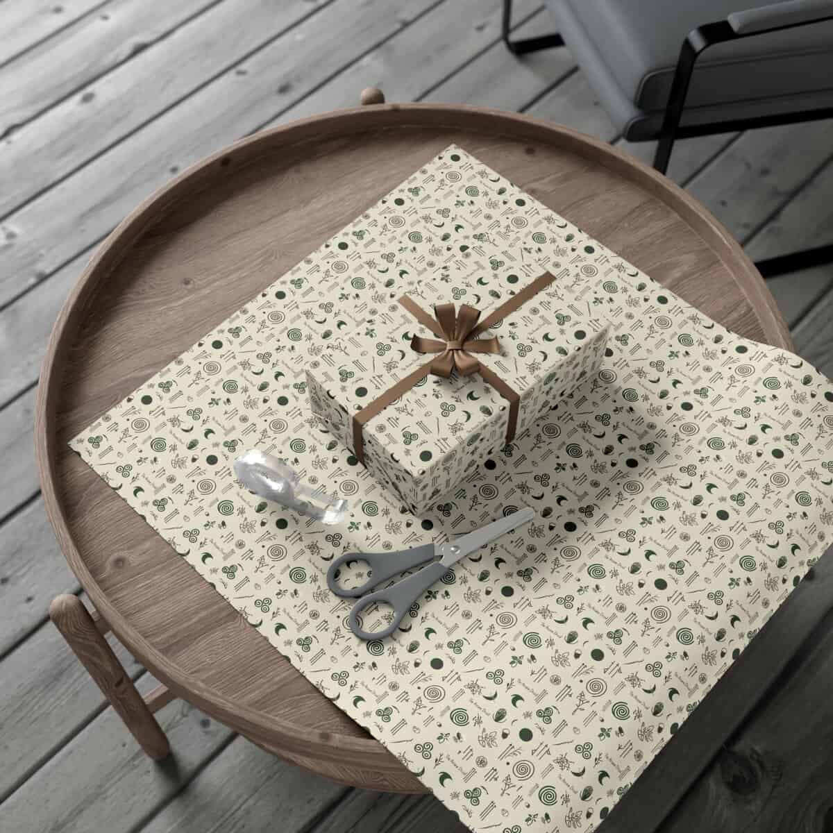 Wrapped gift with Celtic-inspired paper, scissors, and tape on a rustic wooden table.