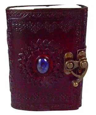 Ancient leather-bound book with embossed cover and metal clasp, possibly used for spiritual or ritua.