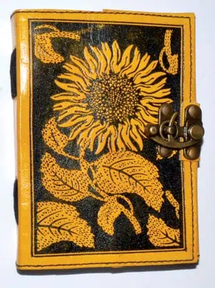 A small book with a sunflower design on the cover, featuring a metal clasp, related to Celtic spirit.
