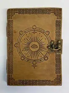 Old book with Ogham symbols and a metal lock, related to Celtic spirituality and druidry.