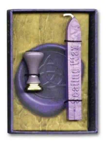 Druidic tools including a stamp and ogham stone in a wooden box, used for Celtic spiritual practices.