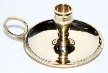 A brass candle holder with a circular base and a central holder for a candle.