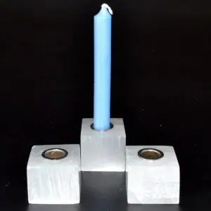 Candle holder with blue candle, simple design, on a black background.