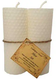 Candle with textured surface and attached tag, used in Celtic spiritual practices.