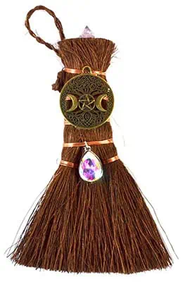 Broom with charms and crystal pendant, related to Celtic spirituality and nature rituals.