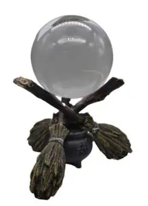 Crystal ball on wooden stand with carved details and pentagram symbol.