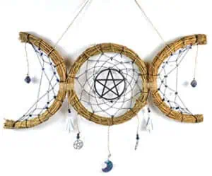Handmade dreamcatcher with pentagram and moon charms, symbolizing Celtic spirituality and nature con.