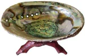 Stone bowl with carved interior on a wooden stand, used in Celtic spiritual and ritual contexts.