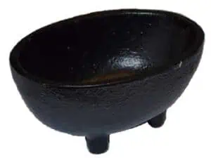 Black stone cauldron with three legs, used in Celtic spiritual practices.