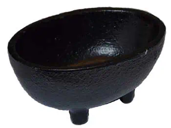 Black stone cauldron with three legs, used in Celtic spiritual practices.