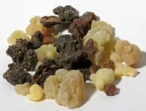 Stone and mineral fragments, varying in color and size, arranged on a white background.
