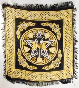 Celtic knotwork and symbolic design on a black and gold cloth, featuring a central figure and intric.
