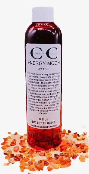 Bottle of Energy Moon Water surrounded by Himalayan salt crystals, on a white background.