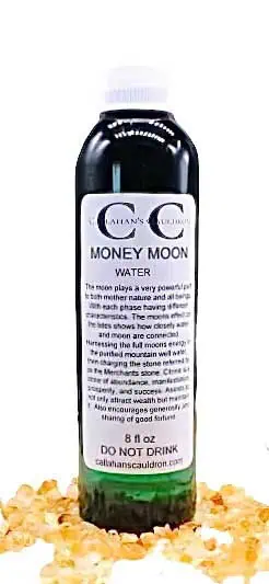 Bottle of water labeled "Money Moon Water" with a white cap, placed on a bed of small stones or grai.