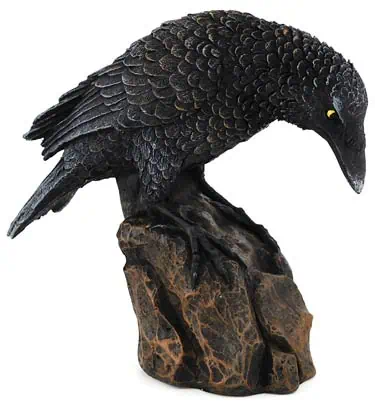 A detailed black raven sculpture with textured feathers, sitting on a natural-looking rock base.