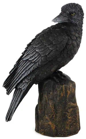 A detailed sculpture of a black crow perched on a textured wooden base.