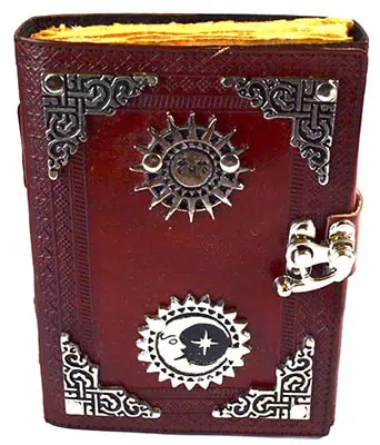 Close-up of a leather-bound Celtic-style book with metal embellishments and ogham symbols.